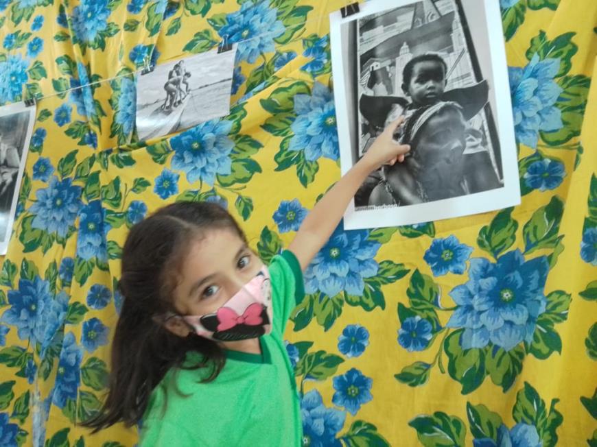 Valentina, de 7 anos, fica encantada com a criança na foto vestida de anjinho