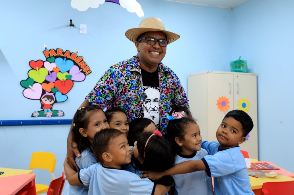 O professor de Artes Cleber Sandim, com crianças atendidas na UEI Monte Alegre