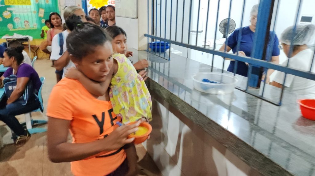 Na hora da merenda escolar, as crianças também se juntam às mães e pais