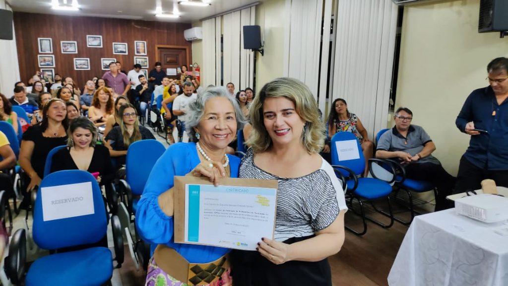 A secretária municipal de Educação, Araceli Lemos (camisa azul), certifica professora que concluiu o curso de 170h: ferramenta de conhecimento e cidadania
