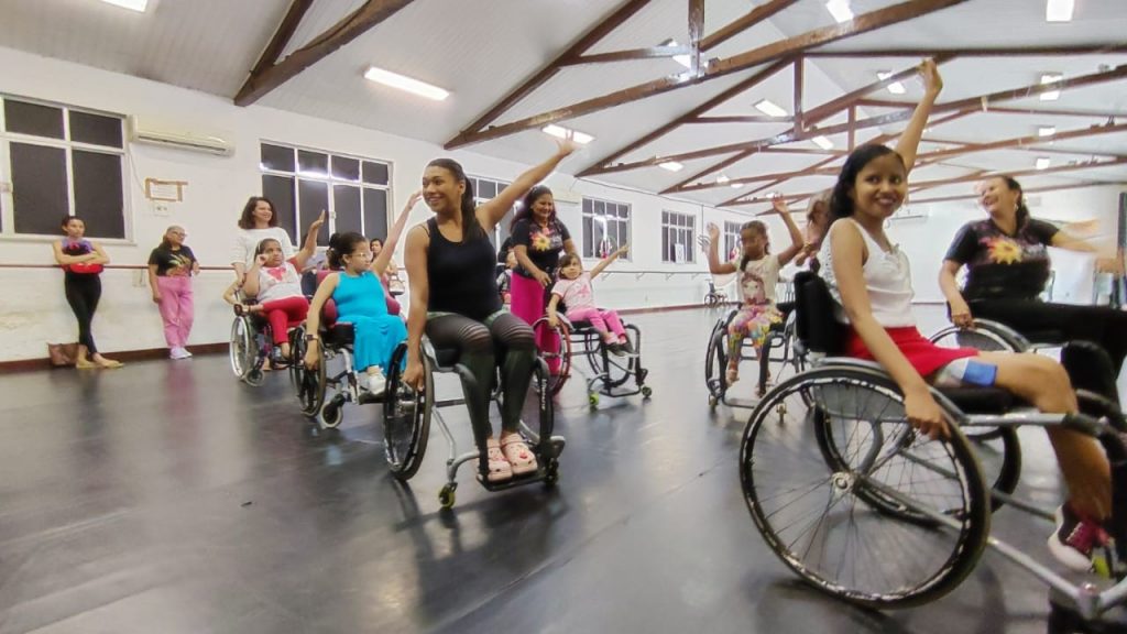 Movimentos de dança em cadeira de rodas. Os estudantes da rede municipal se divertiram.