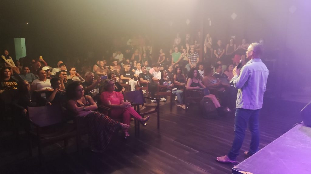 O professor John Souza, coordenador do projeto, comenta sobre as músicas e os temas com o público: "É mais do que música"