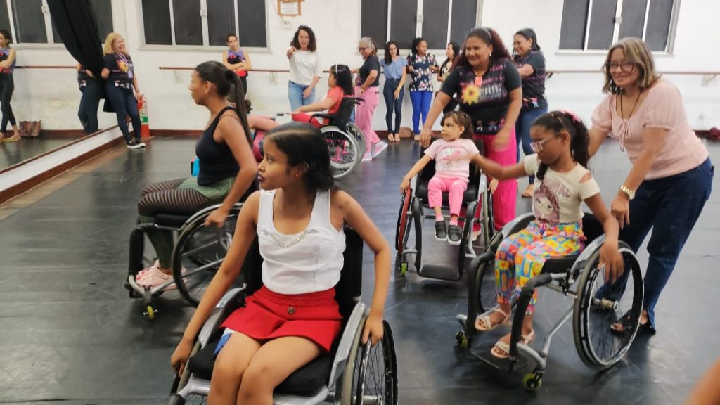 Estudantes com deficiência e responsáveis aprendendo a dançar