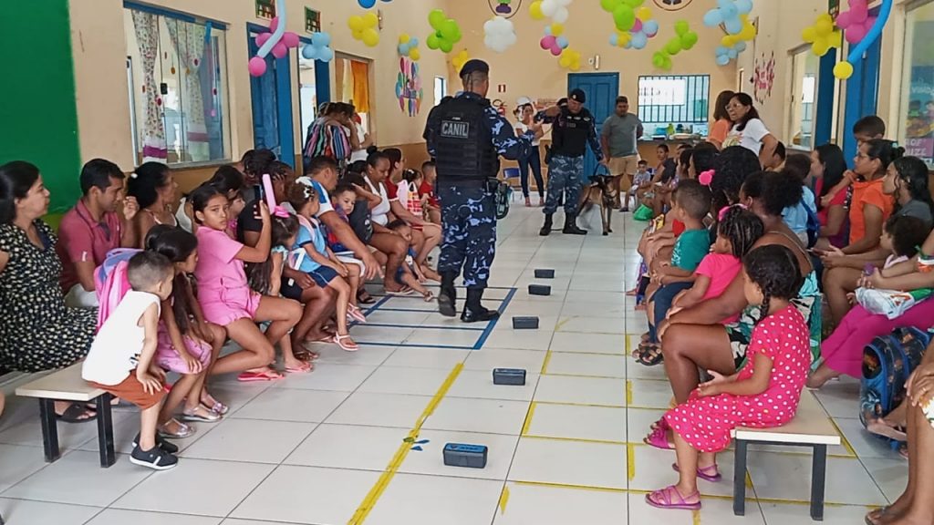 Estudantes assistem atentos à demonstração de obediência do cão Rico, da Guarda Municipal.